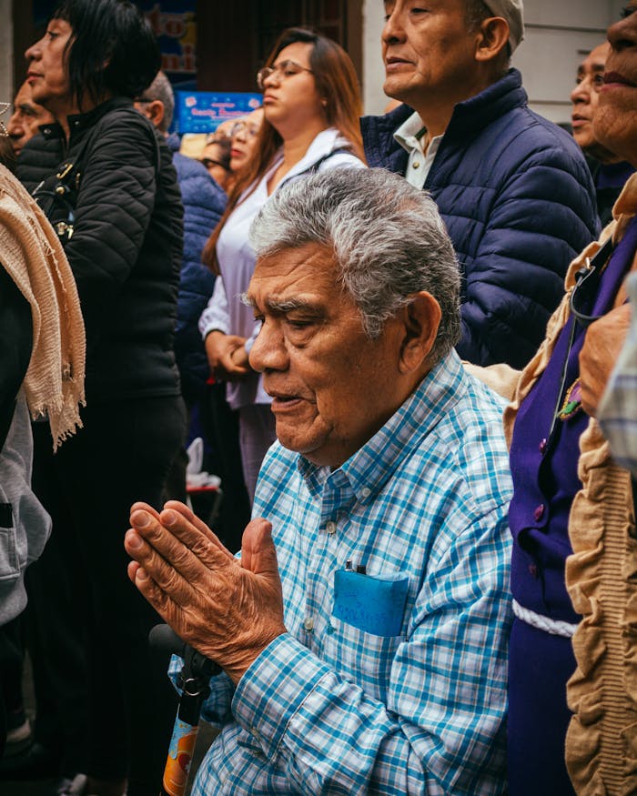 Group of diverse adults praying outdoors in a public gathering, showcasing spirituality and unity.